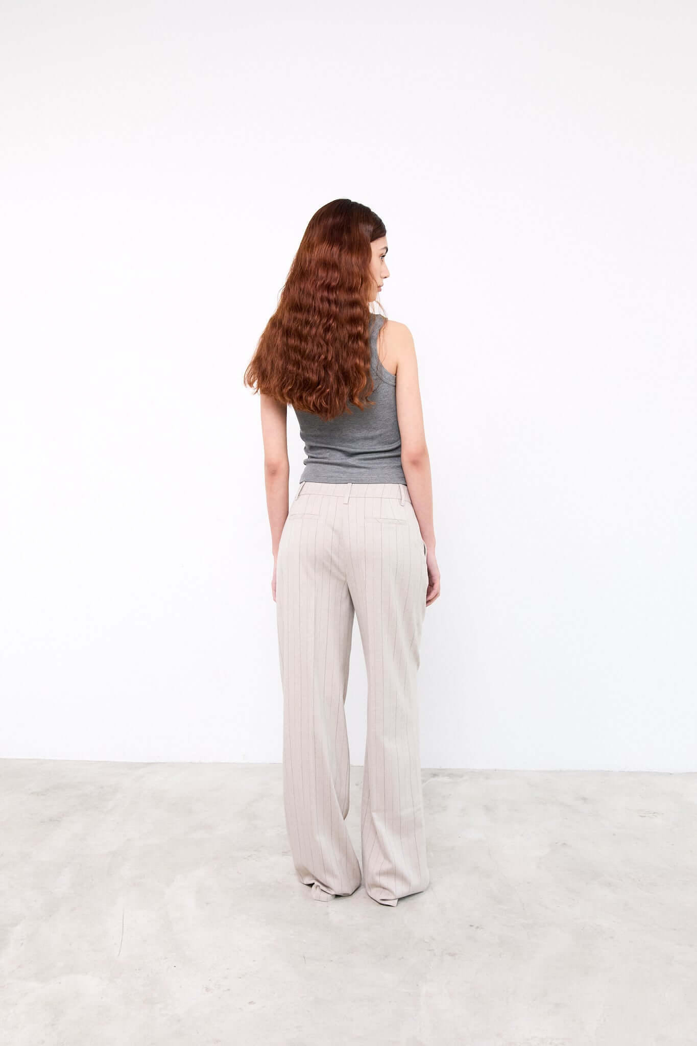 Woman wearing a gray top and beige pants