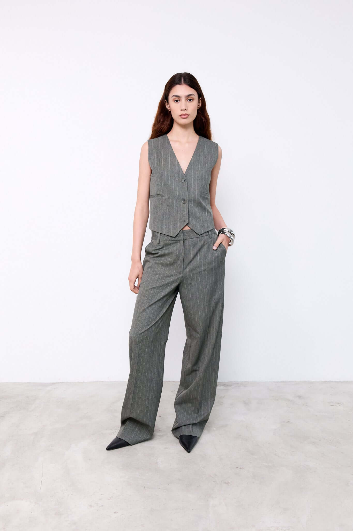 Woman wearing a gray houndstooth patterned vest and pants