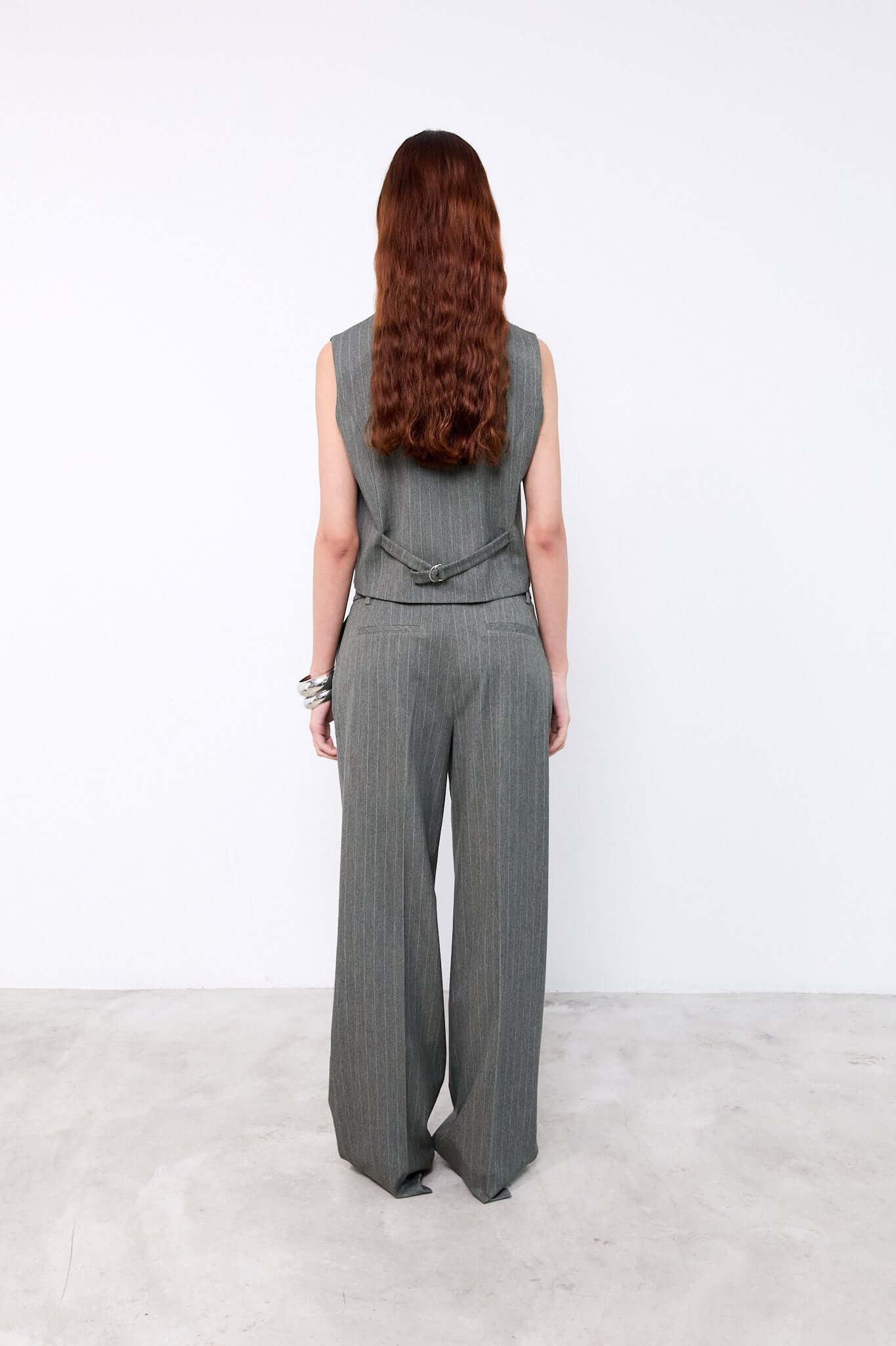 Person wearing a gray sleeveless top and wide-leg pants