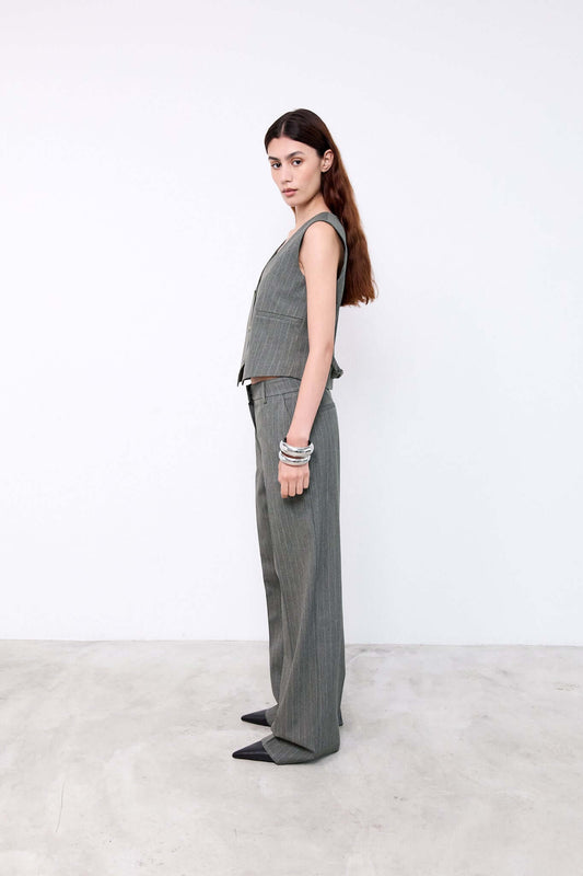 Woman wearing a gray sleeveless top and pants