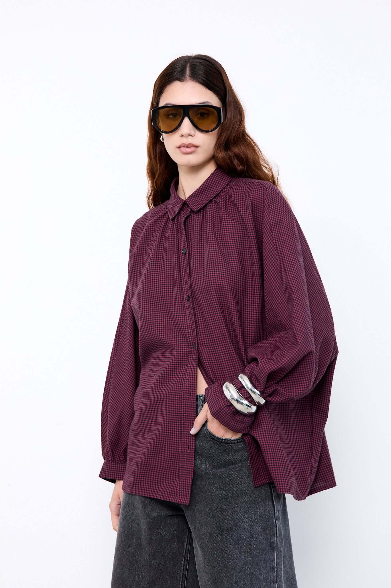 Woman wearing a burgundy patterned shirt and sunglasses