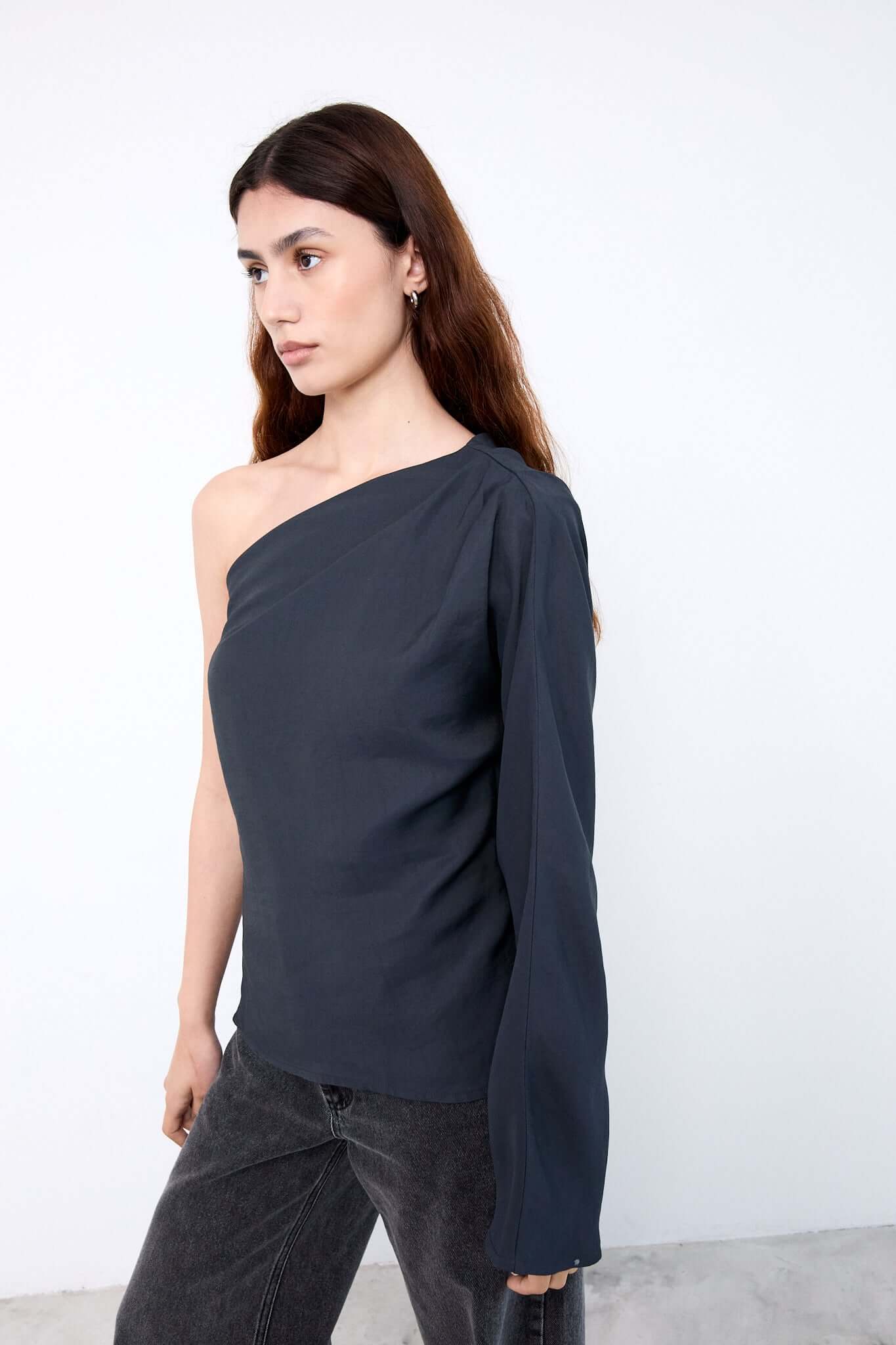 Woman wearing a dark blue one-shoulder top