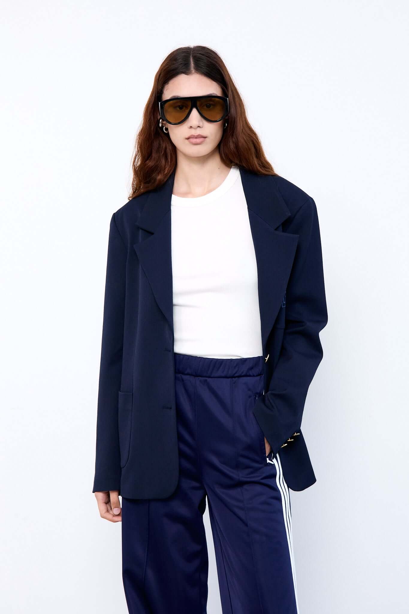 Woman wearing a navy blue suit and sunglasses