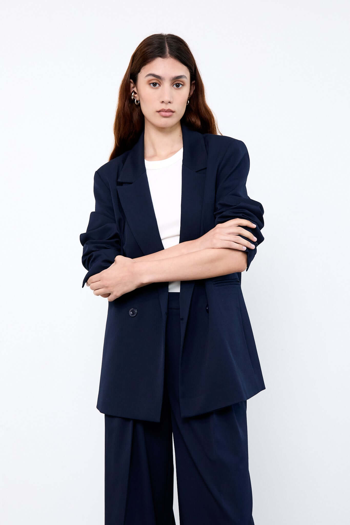 Woman wearing a navy blue suit with a white top