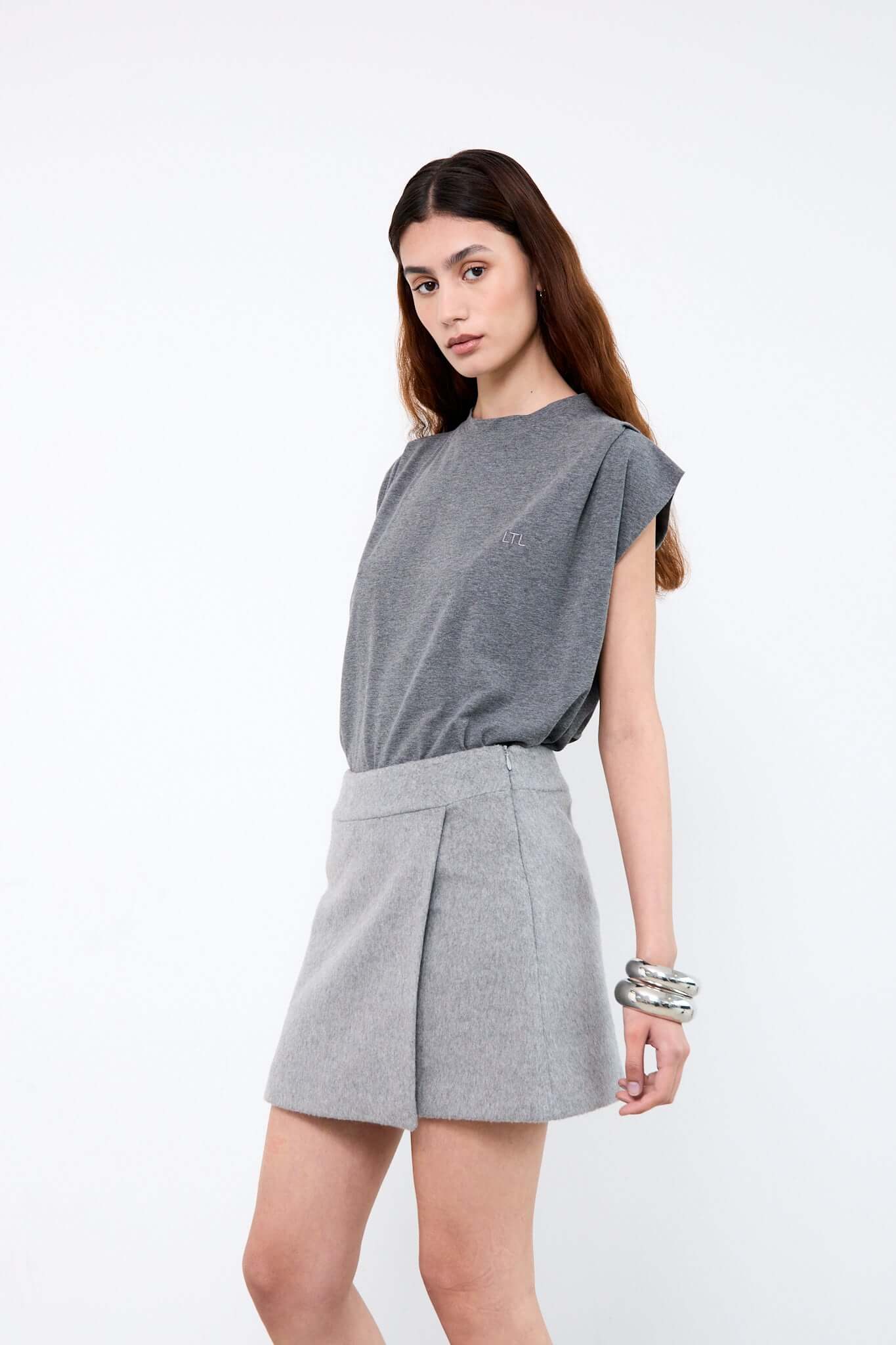 Woman wearing a gray top and skirt