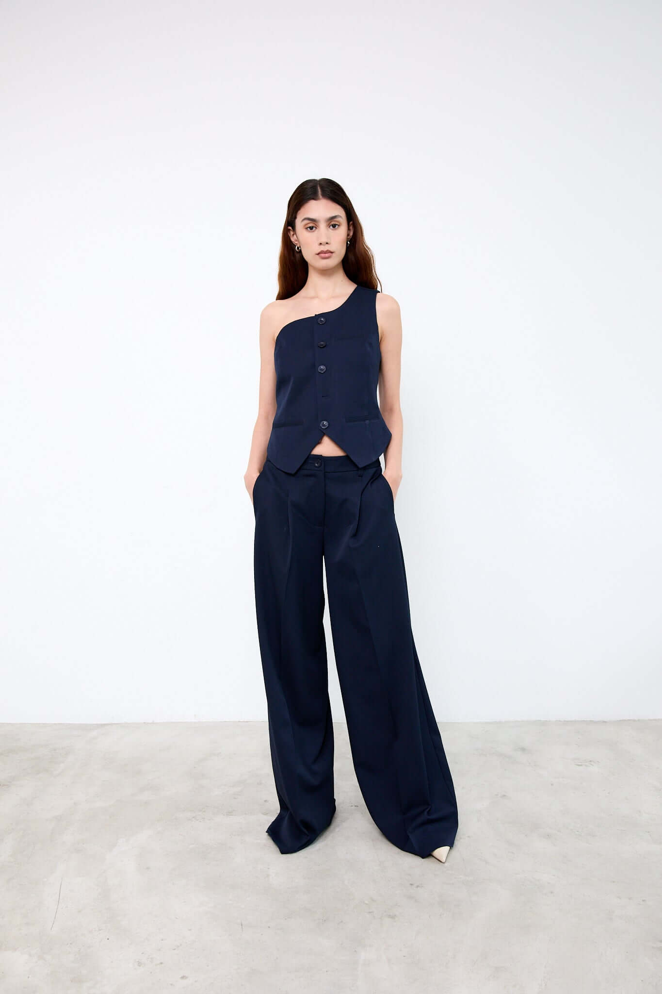 Woman wearing a navy one-shoulder top and wide-leg pants