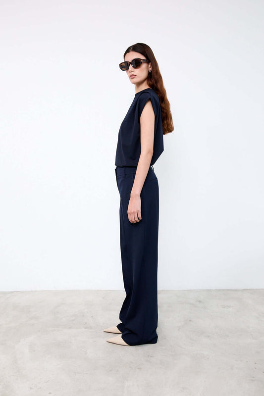 Woman wearing a navy outfit with sunglasses