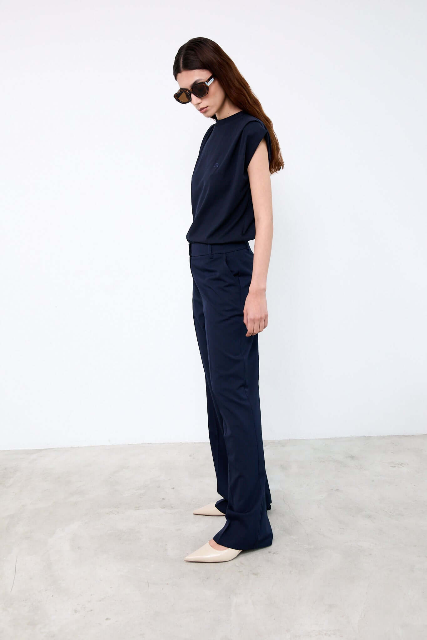 Woman wearing a navy outfit with sunglasses