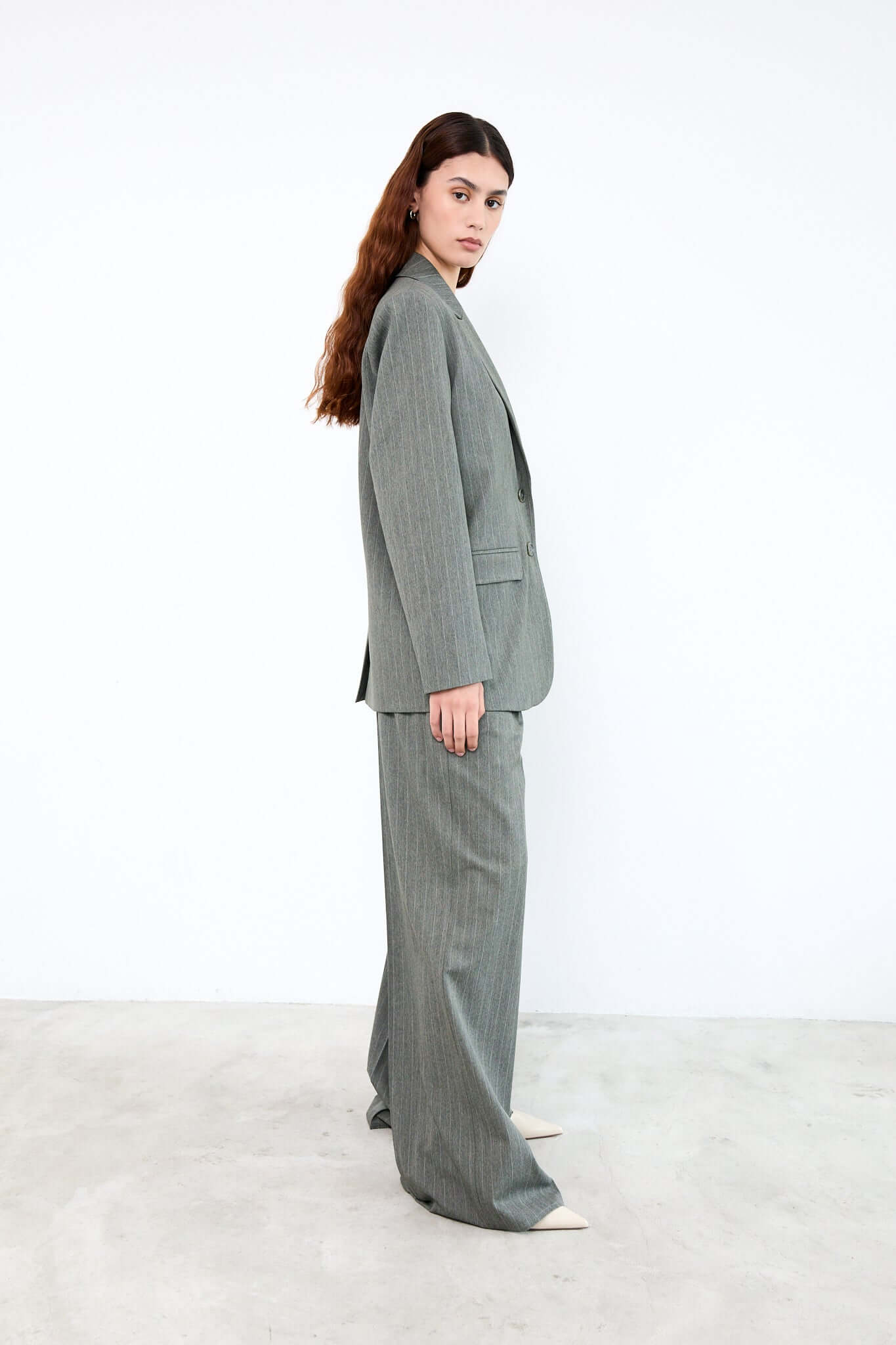Woman wearing a gray suit standing