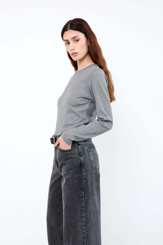 Woman wearing a gray sweater and black jeans