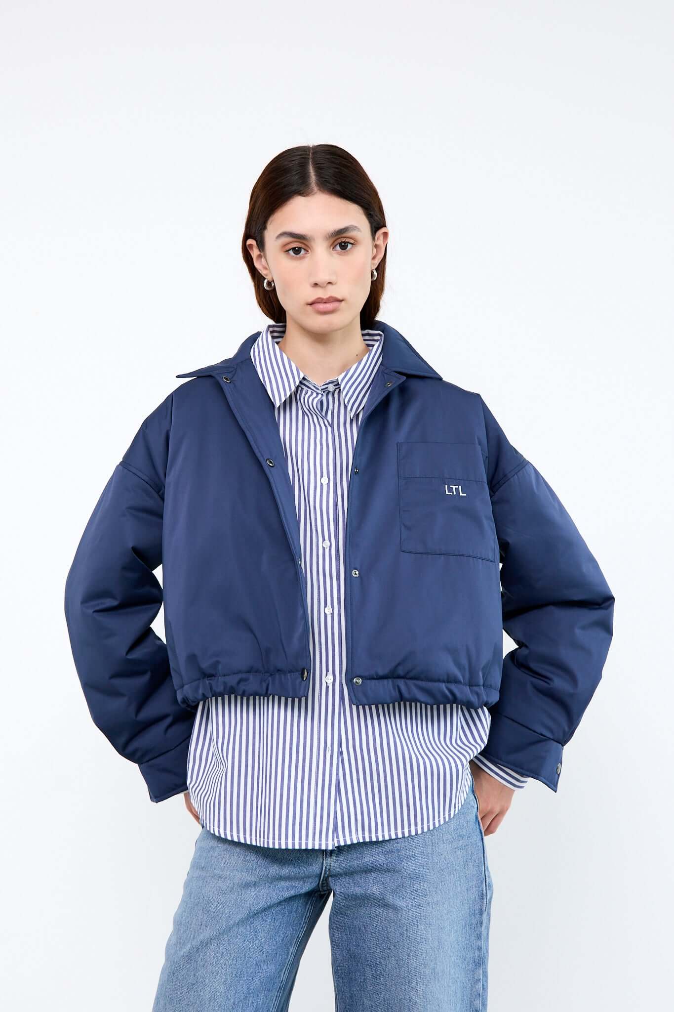 Person wearing a blue jacket over a striped shirt