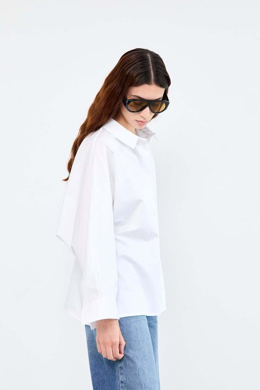 Woman wearing a white shirt and blue jeans on a white background