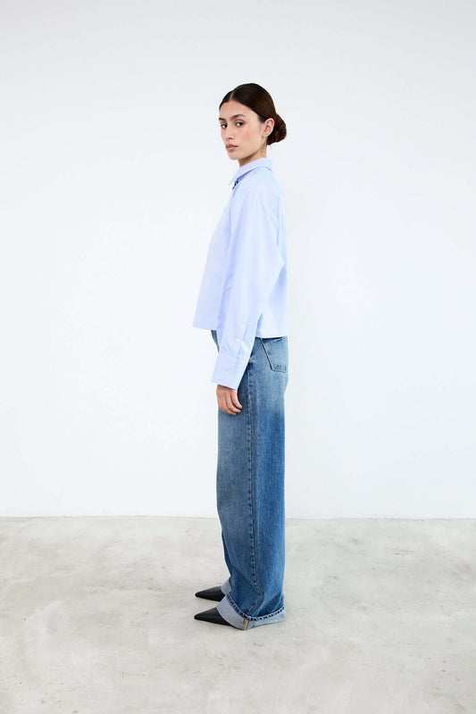 Person wearing a light blue shirt and jeans