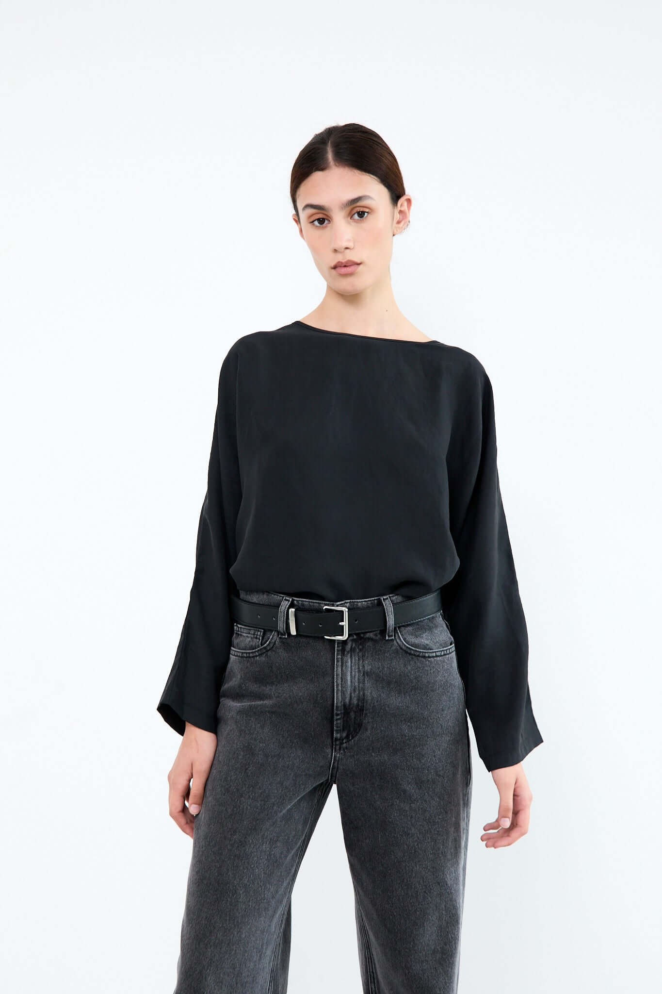 Woman wearing a black blouse and gray jeans