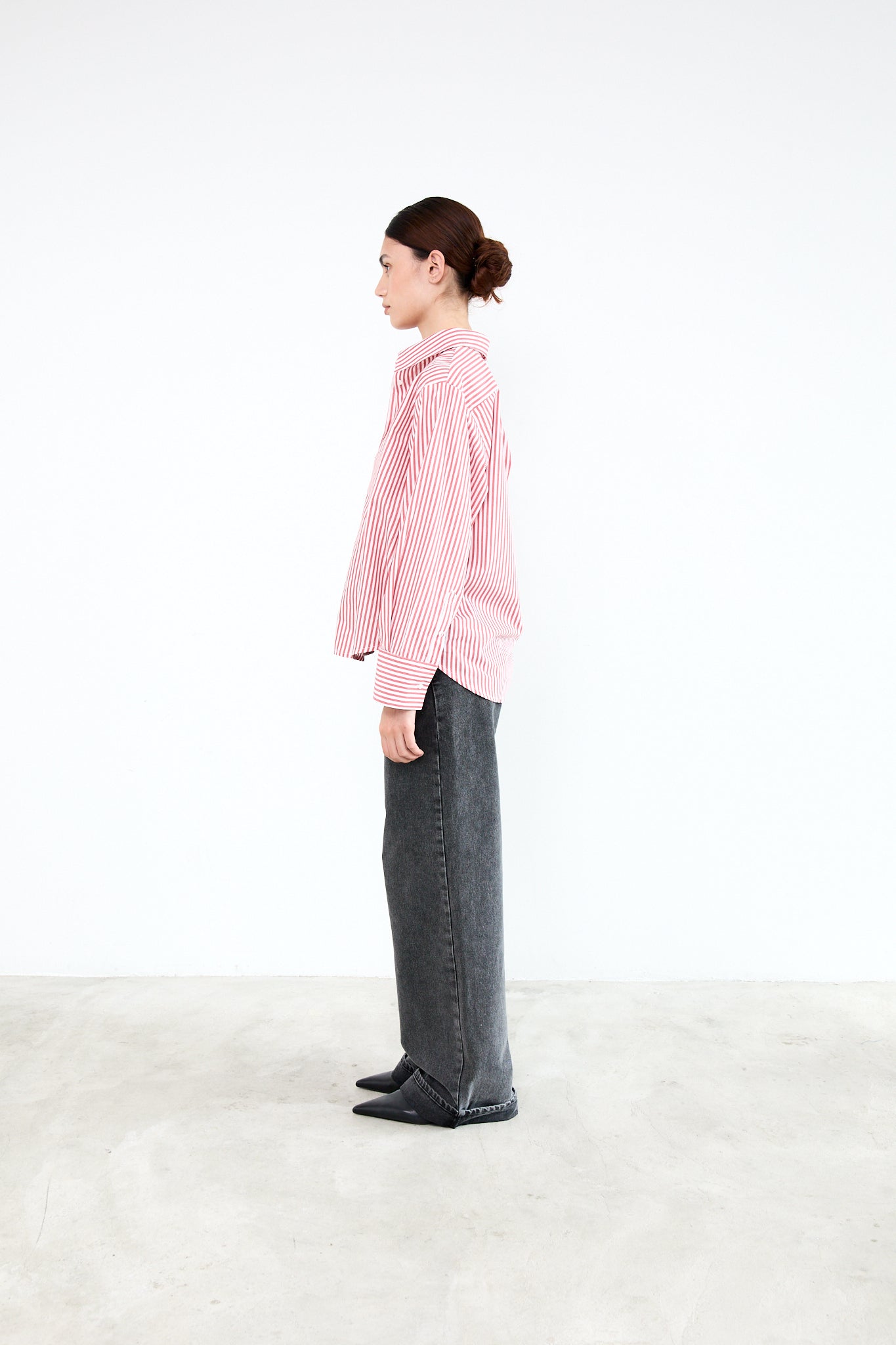 Person wearing a pink checkered shirt and dark pants