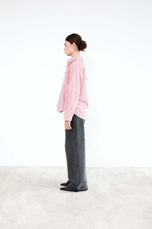 Person wearing a pink checkered shirt and dark pants