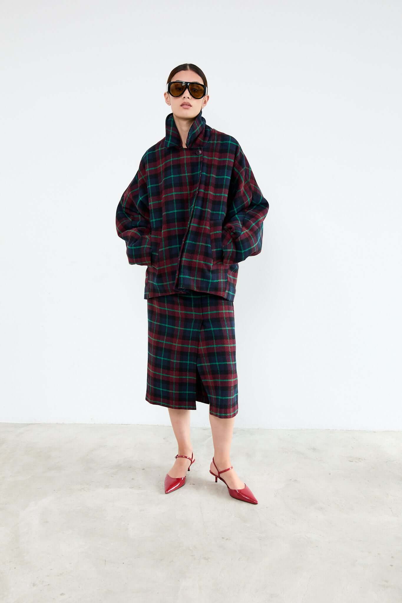 Person wearing a plaid outfit with sunglasses