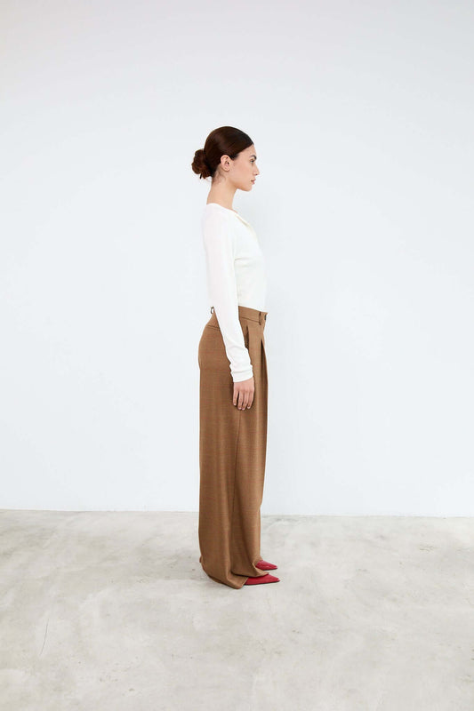 Woman wearing a white top and brown pants