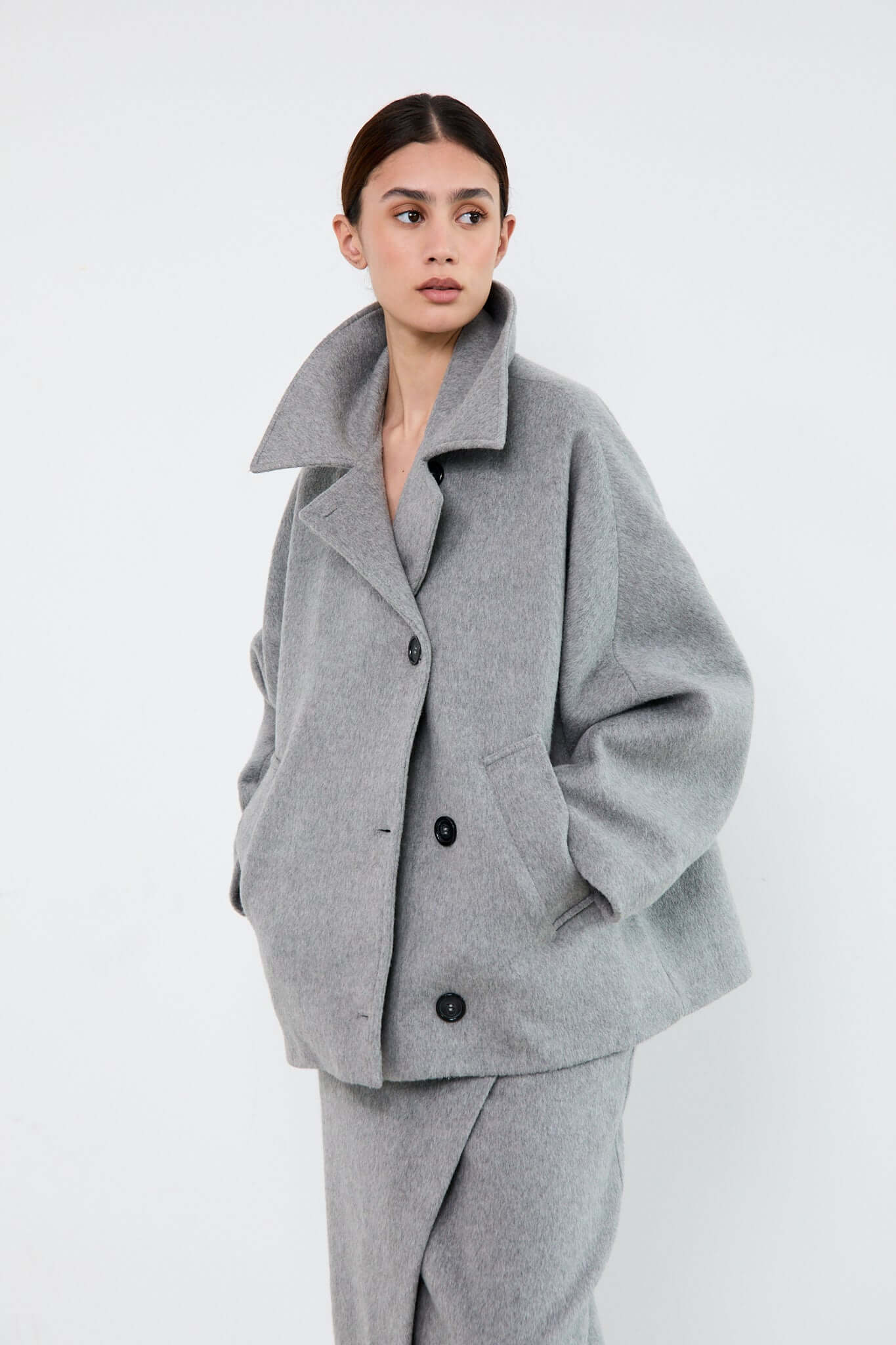 Woman wearing a gray coat and pants