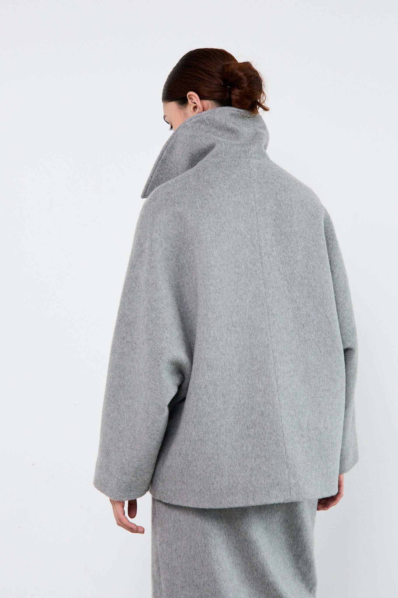 Person wearing a gray coat and pants