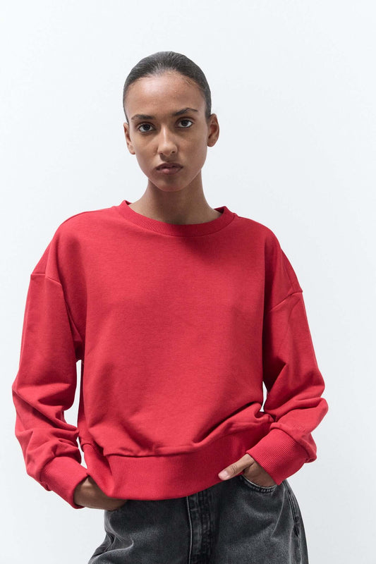 Person wearing a red sweatshirt against a white background