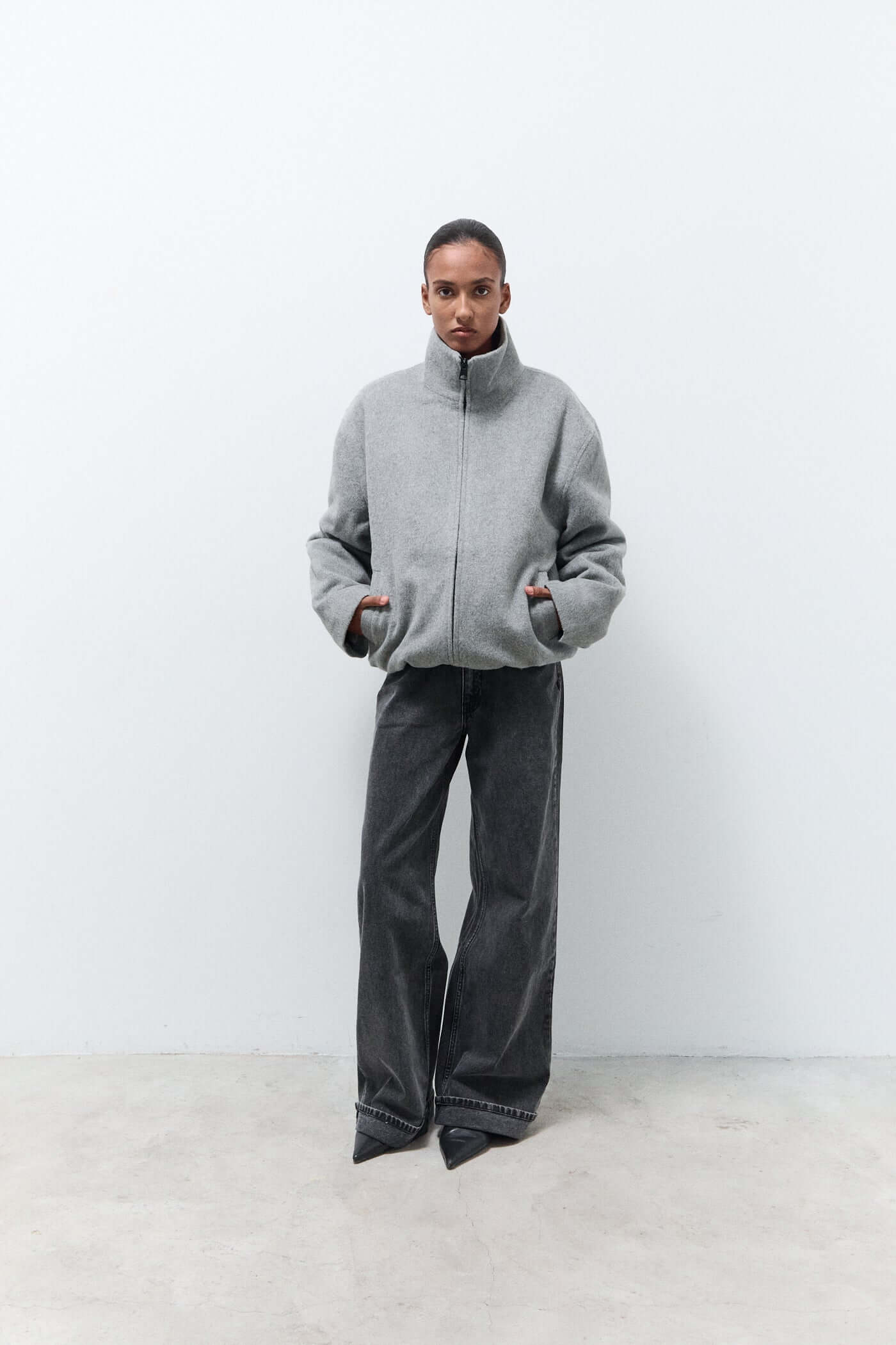 Person wearing a gray jacket and dark pants