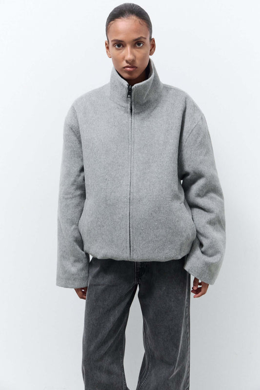 Person wearing a gray zip-up jacket and pants