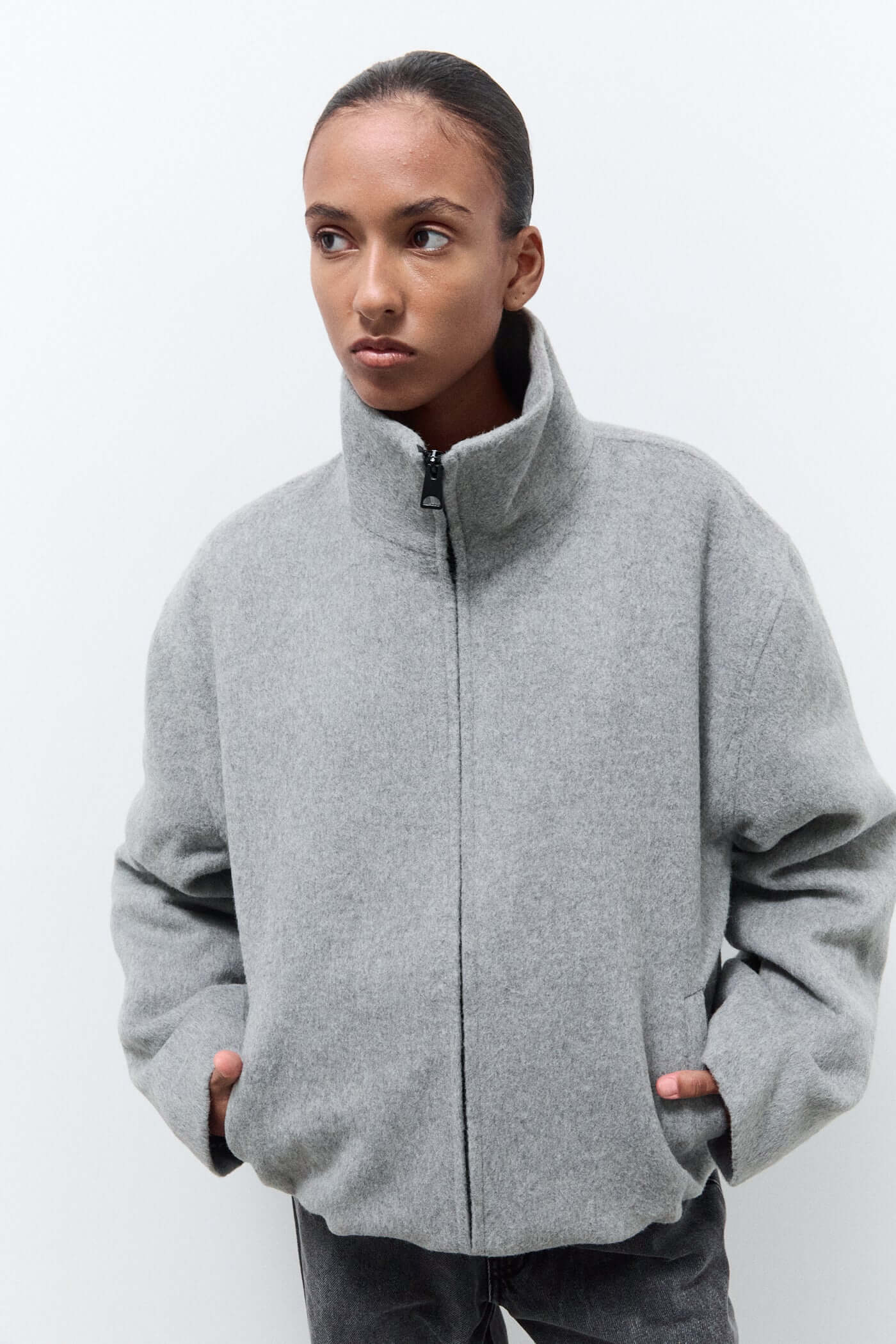 Person wearing a gray zip-up jacket