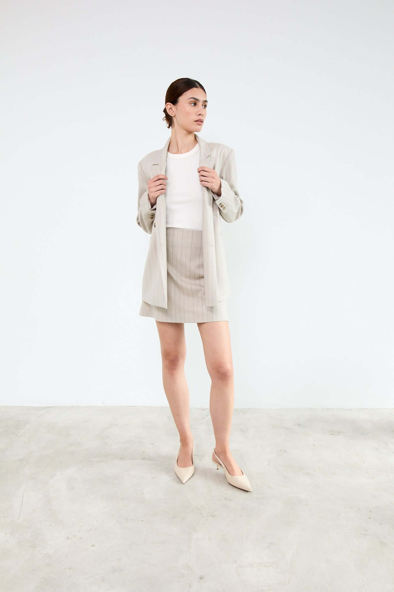 Woman wearing a beige blazer and skirt