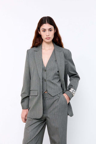 Woman wearing a gray pinstripe suit on a white background