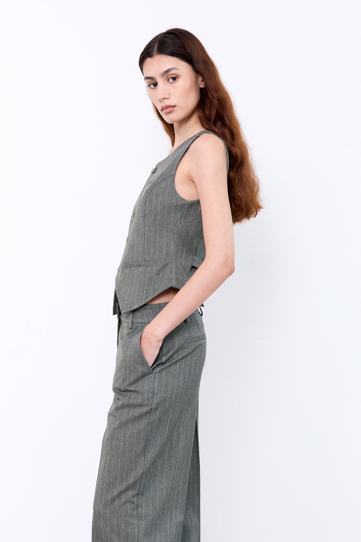 Woman wearing a gray sleeveless top and pants 