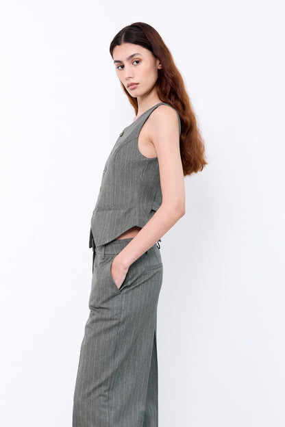 Woman wearing a gray sleeveless top and pants 