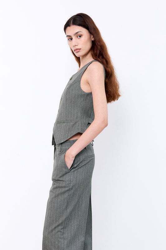 Woman wearing a gray sleeveless top and pants 