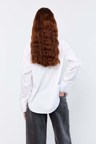 Person wearing a white shirt and gray pants