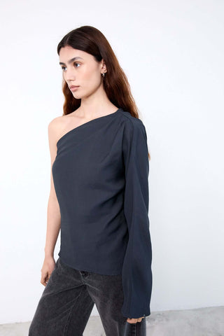 Woman wearing a dark blue one-shoulder top 