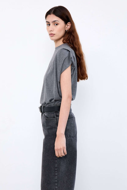 Woman wearing a gray top and black pants 