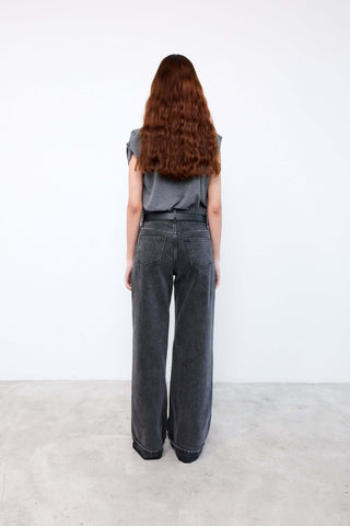 Person wearing gray wide-leg jeans and a gray top