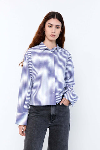 Woman wearing a blue and white striped shirt with black pants