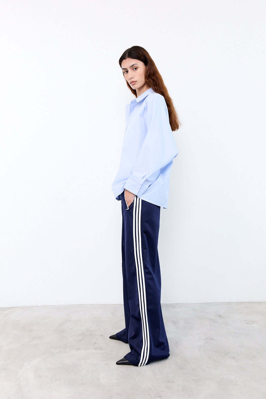 Woman wearing a light blue shirt and navy pants 