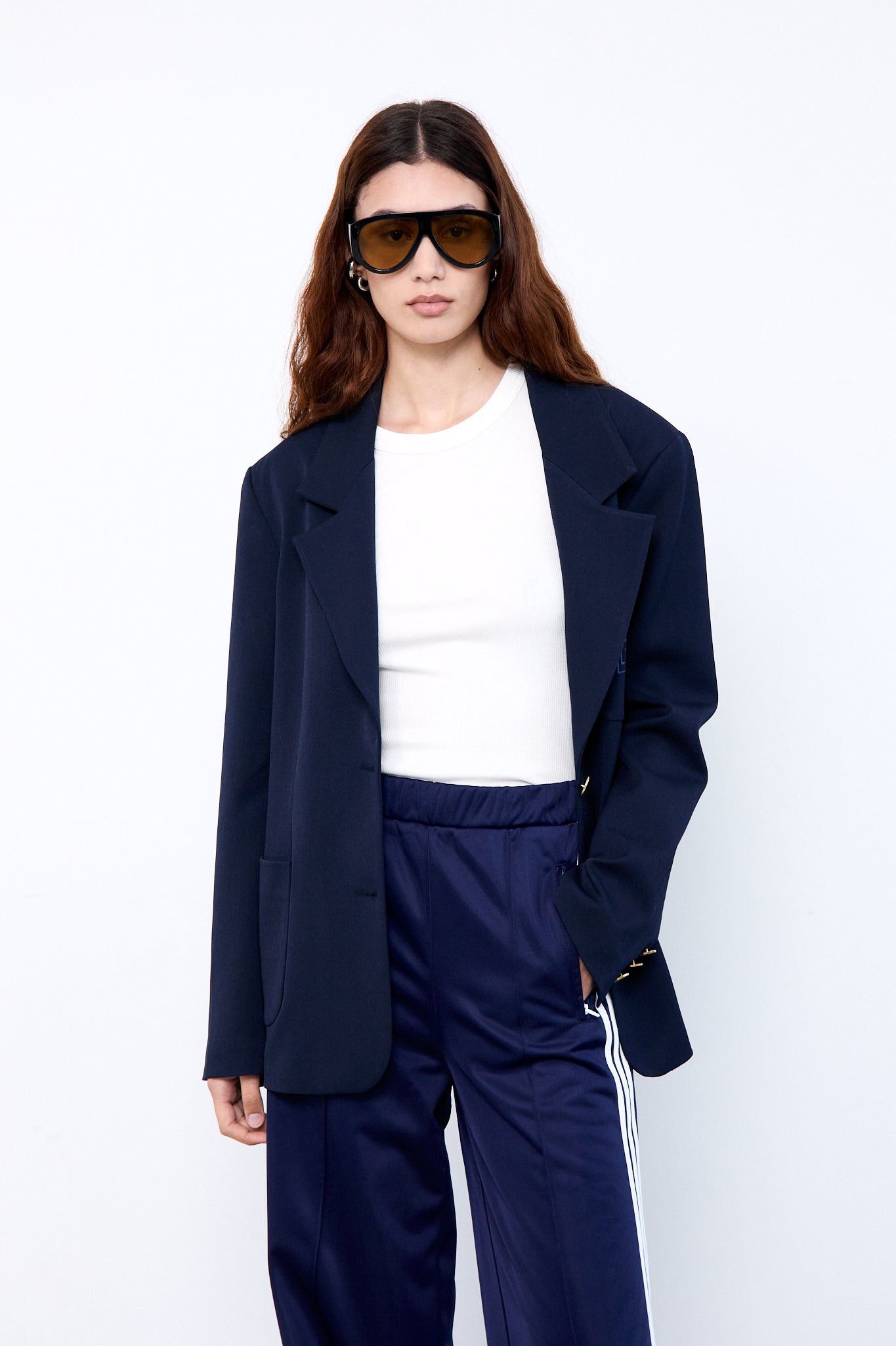 Woman wearing a navy blue suit and sunglasses 