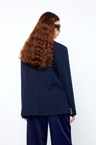 Person wearing a navy blue blazer and pants 