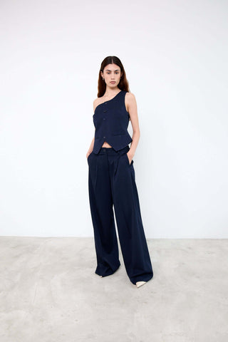 Woman wearing a navy one-shoulder top and wide-leg pants