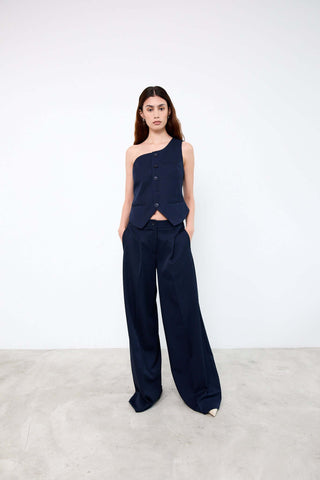 Woman wearing a navy one-shoulder top and wide-leg pants 