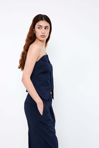 Woman wearing a navy blue sleeveless top and pants 