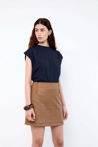 Woman wearing a navy top and brown skirt