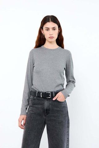 Woman wearing a gray sweater and black jeans