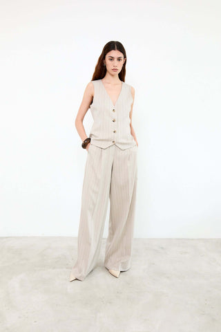 Woman wearing a beige sleeveless top and wide-leg pants 