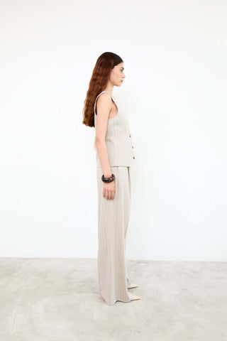 Woman wearing a beige sleeveless top and pants 