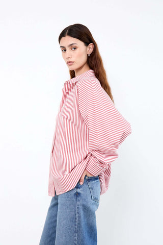 Woman wearing a red and white striped shirt and blue jeans 