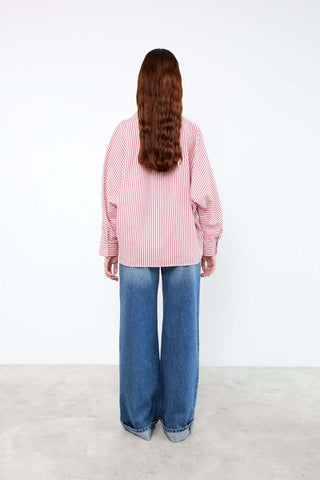 Person wearing a pink striped shirt and blue jeans